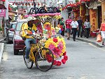 ジョンカーストリートを流す花飾りの観光人力車トライショー